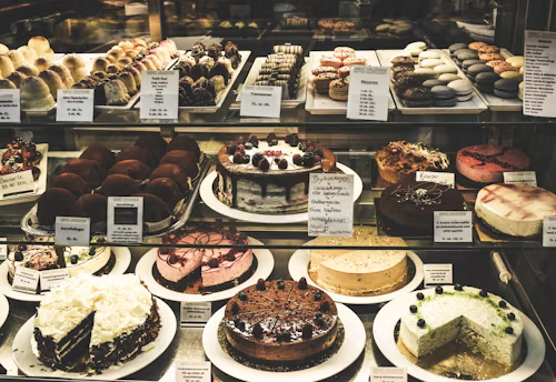 a variety of cakes displayed in a cake display